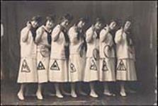 Seven women in sports dress holding tennis rackets - team photo [1920]