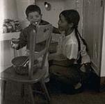 [Sam Houston and an Inuk girl baking] 1960