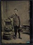Boy holding a hat, leaning against a column [ca 1875-1910]