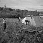 Audrey James, Anna Brown and Helen Salkeld erecting tents, Moonbeam, Ontario 1 août 1954