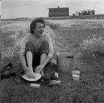 Makeshift bath in Prairies. Audrey James washing up, Portage-la-Prairie, Manitoba. August 5, 1954.