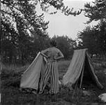 Anna Brown en train de s'habiller sur un site de camping dans la vallée Qu'Appelle, en Saskatchewan? août 1954.