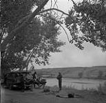 Helen Salkeld, Anna Brown et Audrey James en train d'installer leur campement, près de la rivière Oldman, Alberta 10 août 1954.