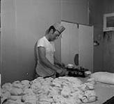 Baker working at Don's Bakery, Steinbach, Manitoba June 1, 1956.