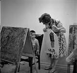 Teacher Jackie Otis holding a boy's painting during an art class, Calgary Allied Arts Centre août 1962.
