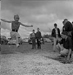 Woman executing a long jump, Swan River, Manitoba June 30, 1956.