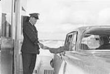 Man in Car Passing Money to Border Agent [ca.1954-1963]