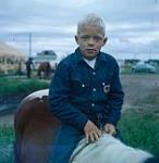 Boy sitting on a horse at Swan River round-up, Manitoba June 30, 1956.