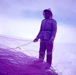Fisherman holding a fishing net, Peter Pond Lake, Saskatchewan mars 1955