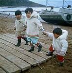 Three children holding hands at Apex, Frobisher Bay, N.W.T., [Iqaluit (formerly Frobisher Bay), Nunavut] [between June-September, 1960].