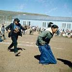 Course en sac pendant la Fête du Canada, baie Frobisher, T.N.-O., [Iqaluit (anciennement baie Frobisher), Nunavut] July 1, 1960.