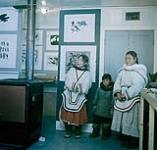 Sheouak (gauche), son garçon et une amie pendant une visite à la West Baffin Co-operative, Cape Dorset, Nunavut août 1960.