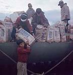 Garçons participant au déchargement d'une barge de la Compagnie de la Baie d'Hudson à Apex, baie Frobisher, T.N.-O., [Iqaluit (anciennement baie Frobisher), Nunavut] [between June-September, 1960].