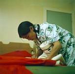 [Nepitia] cutting fabric for a parka, [Cape Dorset, Nunavut] [entre 24 aout-3 octobre 1960].