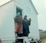 Deux femmes et deux garçons à l'extérieur du magasin Co-op Kikitayok, île Killiniq, Nunavut [between June-September, 1960].