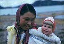 Alicat, bonne d'enfants, transportant Farleigh Allatt sur son dos, Cape Dorset, Nunavut [entre juin-septembre 1960].