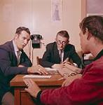 Wm. J. Brown, Welfare Officer for the St. Barbe District, obtaining advice from Magistrate White on Delinquency problems, at Magistrate's Office in the Court House at Woody Point, Bonne Bay, Newfoundland August 1960