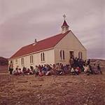 Worshippers congregating outside the Anglican Church at Cape Dorset, Baffin Island. juillet 1961