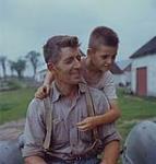 An excellent portrait of a farmer with his son on his shoulders at Yamachiche, Québec.  1957