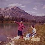 [A man and a woman on a river's shore, Alberta] August 1956