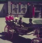 The state carriage brings The Right Honourable Vincent Massey and his staff to Parliament Hill for the coronation ceremonies. Ottawa. Ontario. juin 1953.