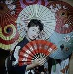 Miss Ruby Mosaki, one of the dancers of the Manitoba Japanese Association, posing in whirl of gay parasols. 1960