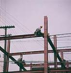 [Construction worker sitting on metal beam of framework during construction of the Teron Building, Ottawa, Ontario.] May 1961.