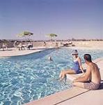 Free form swimming pool at Rideau Towers luxury apartments overlooking City of Calgary, Alberta. juillet 1961