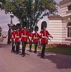 Canadian Guards wearing bearskin hats marching on path. Ottawa, Ontario. septembre 1961