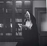 Religieuse dans la bibliothèque du couvent Notre-Dame, Sherbrooke, 1957 1957