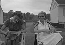 Ryan, Joe, montage négatif 35 mm, deux dames assises sur des chaises sur l'herbe [ca 1939-1951]