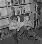 Children's Art Classes, Lismer's, two boys sitting on the floor in front of bookshelves [entre 1939-1951].