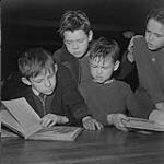 Children's Art Classes, Lismer's, four boys reading a book [entre 1939-1951].