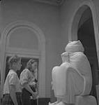 Cours d'art pour enfants, Lismer, deux filles regardant leur sculpture [between 1939-1951].