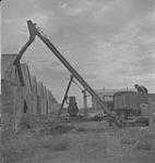 Saskatoon et blé, hommes opérant un équipement de chargement du grain [entre 1939-1951].