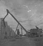 Saskatoon & Wheat, men operating grain loading equipment [between 1939-1951].