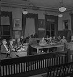 Saskatoon et blé, groupe d'hommes assis à des bureaux [entre 1939-1951].