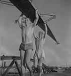 Vancouver. Deux hommes non identifiés en culottes courtes transportent des deux rames sur la tête [entre 1939-1951].