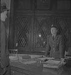 Service féminin de l'Armée - Femme non identifiée en uniforme debout derrière un bureau December 1941