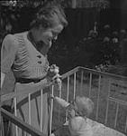 Winnipeg, années 1940. Plan rapproché d'une femme et d'un bébé non identifiés en train de jouer [between 1940-1949]