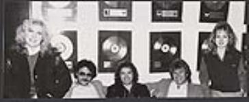 Shown seated are (left to right): Gail O'Brien (Director of Promotion - Solid Gold), Steve Propas (President - Solid Gold), Alex Machin, Neill Dixon (Vice President - Solid Gold), and Tracy Keizer (Director of Publicity - Solid Gold) [ca. 1984].