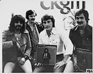 L'artiste de studio d'enregistrement Myles promouvant son album Start All Over Again. De G à D : Myles, Frank Iacouella (promotion de MCA au Québec et directeur A&R), John Reogh (directeur musical, CKGM-AM Montréal), Keith Patten (promotion nationale de MCA) [ca 1979]