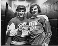 Portrait of (L to R): CFTR's Dewe Lewis and Metro Toronto policeman, 14th Division, wearing hockey gear. Toronto [between 1970-1980]