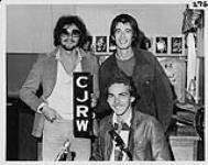 Portrait de Ken Laderoute et John Baye de la Great Rufus Road Machine avec le DJ Mike McCary de CJRW. Summerside, Île-du-Prince-Édouard [entre 1976-1979].