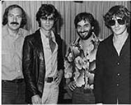 L to R: Duff Roman (CHUM-FM), Robbie Robertson (The Band), Chuck Azzarello (CHUM-FM), Rick Danko (The Band) [entre 1975-1976].