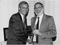 Bernie DiMatteo and an unidentified man. One man is presenting a Juno Award. [entre 1990-2000]