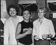 George Belanger of Harlequin posing with Mario Lefebvre of CBS Records (left) and Steve Anthony of CKGM-Montreal (right) [between 1979-1985].