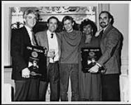 Lance Freed (président, Almo Irving), Jack Losmann (vice-président aux affaires internationales, A&M Inc.), Brenda Andrews (vice-présidente aux activités professionnelles, Almo Irving) et Gerry Lacoursiere (président, A&M Records Canada) à Vancouver lors de la remise d'un disque de diamant à Bryan Adam décembre 1985