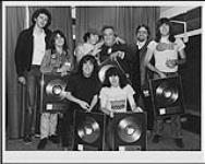 Group portrait of the band AC/DC after being presented with Platinum Awards for their album Flick of the Switch following their concert at Toronto's Maple Leaf Gardens [entre 1983-1984].