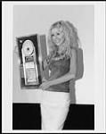Press portrait of Christina Aguilera holding her award from RCA for over 400,000 copies of her self-titled 1999 recording May, 2000